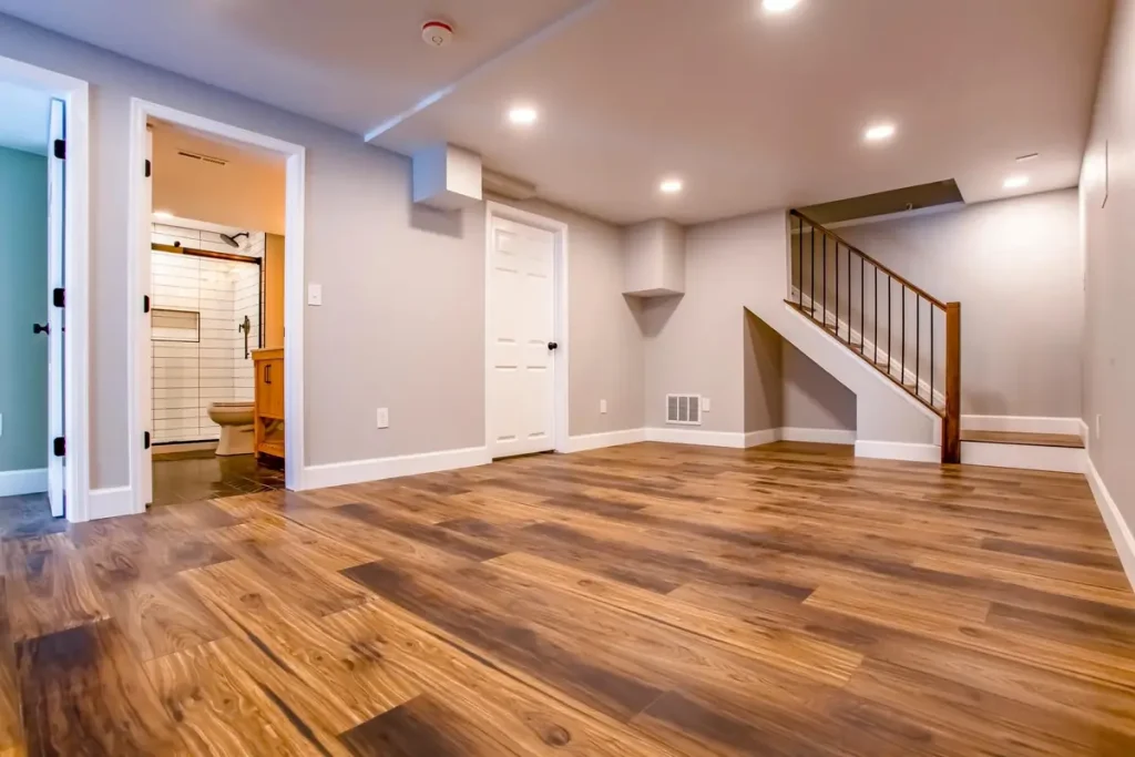 Finished basement with wood-look floors, a bathroom, and a stairway
